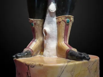 Close-up of the Moor of Borghese statue showing the lower legs, bare feet, and carved boots above a marbled pedestal.