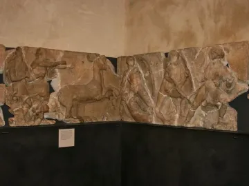 Bassae Frieze marble relief panels showing draped figures, a deer-like animal, and a centaur in a battle scene.
