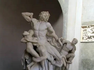 Laocoön and His Sons marble sculpture with a muscular male figure and two younger figures entwined by serpents in an arched gallery