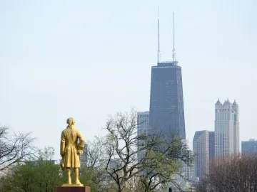 Alexander Hamilton statue seen from behind, with Chicago skyscrapers in the background.