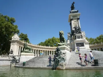 Alfonso XII Monument with a central column and equestrian statue, surrounded by a colonnade beside the lake