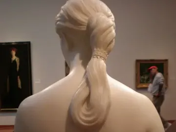 Rear view of California by Hiram Powers, showing the marble bust from behind with a detailed braided ponytail.