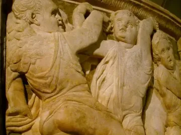 Close-up of Donatello’s Pulpit of Prato Cathedral showing winged putti in a marble relief.