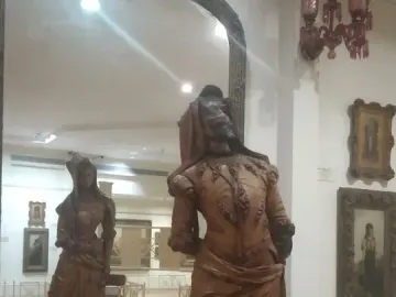 Mephistopheles and Margaretta carved in a tall wooden double-sided statue, with a mirror showing the female figure behind the male figure.