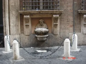 The Porter fountain carved into a wall, with a man holding a barrel as water pours into a basin.