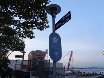 Directional signs for Ballpark Station and the Staten Island September 11 Memorial on a street pole near the waterfront.