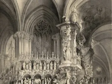 The Transparente altarpiece in Toledo Cathedral with sculpted saints and angels rising toward the vaulted ceiling as people gather below.