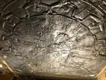The Dendera Zodiac relief, showing a circular ancient Egyptian carving with figures and symbols around a central disk.