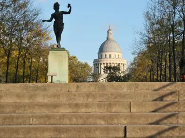 The Greek Actor statue on a pedestal with the Pantheon in the background.