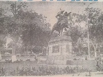 Francisco Pizarro equestrian statue on a stone pedestal in a park with trees and garden beds.