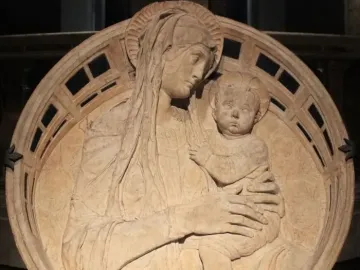 Madonna del Perdono relief showing the Madonna holding the child beneath a decorated arch