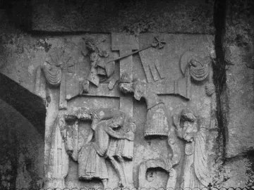 Externsteine Relief carved into a rocky cliff face, showing draped figures around a central cross.