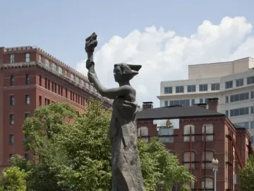Victims of Communism Memorial bronze statue of a draped female figure holding a torch on a dark pedestal.