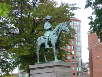 Ambrose Burnside Monument showing an equestrian bronze statue on a stone base inscribed Burnside, with people seated on the steps nearby.