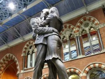 The Meeting Place bronze sculpture of a couple embracing inside St Pancras International Station.