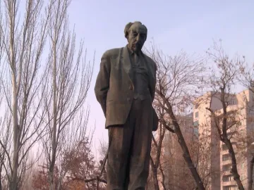 Bronze statue of Avetik Isahakyan standing on a stone pedestal in Yerevan.