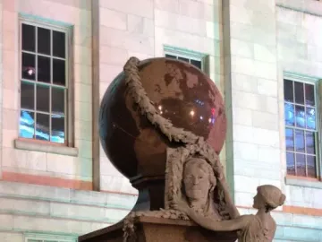 Daguerre Memorial stone sculpture with a bust of Daguerre, a large globe, and a draped female figure with a laurel garland.