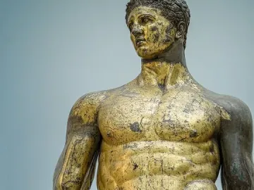 Hercules of the Forum Boarium, a gilded bronze nude male statue holding a club and three round objects.