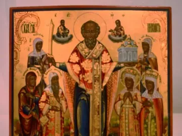 Saint Nicholas of Mozhaysk icon showing a central bearded figure with outstretched hands, flanked by smaller saints and symbolic offerings.