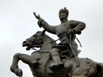 Bronze statue of Damdin Sükhbaatar on a rearing horse, with one arm raised and a sword in hand.