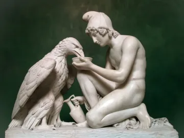 Ganymede with Jupiter\'s Eagle marble sculpture of a kneeling young man offering a dish to an eagle.