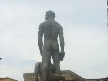 Hercules and Cacus seen from behind, with the muscular standing figure atop another figure on an ornate pedestal.