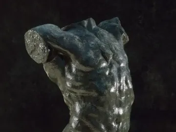 The Falling Man bronze torso mounted on a light-colored base against a dark background.