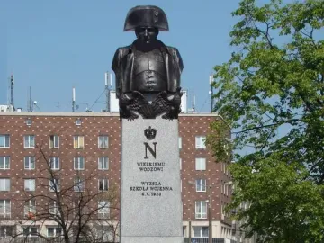 The Emperor Napoleon I Memorial, a tall stone monument with a bronze bust of Napoleon in a bicorne hat and military uniform.