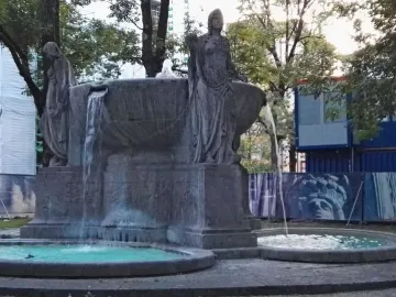 Nornenbrunnen fountain with three draped female figures around a large bowl and smaller basins below