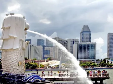 The Merlion statue spouts water into the bay with Singapore’s skyline behind it.