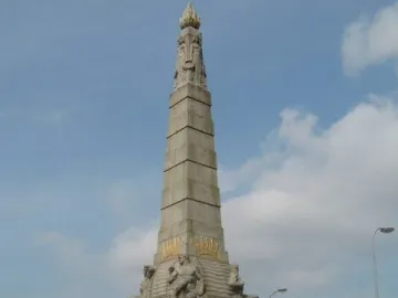 Titanic Engine Room Heroes Memorial stone monument with carved figures and a flame-like top