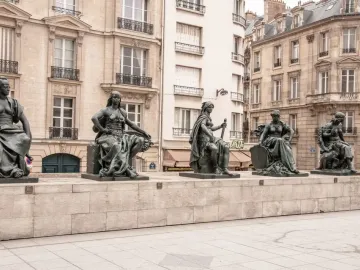 Africa sculpture by Musée d\'Orsay, a dark cast-iron figure seated on a stone plinth with a small lion cub beside her.