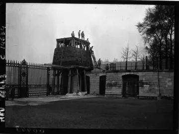 The Marly Horses surrounded by wooden scaffolding and a large conical temporary enclosure near an ornate fence and stone wall.