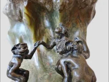 The Wave sculpture with three dark bronze nude figures holding hands on a veined stone base.
