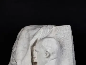 Octave Mirbeau plaster bust in profile, facing left with an open mouth, emerging from a rough draped block.