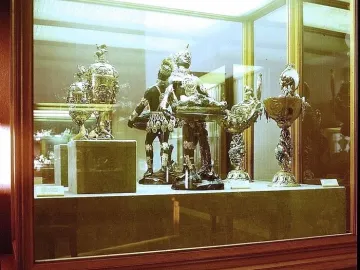 Moor with Emerald Plate holding a shallow dish with green emeralds in a glass display case