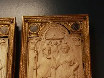 Queriniano Diptych ivory panel showing a man with a staff and a draped woman under an arch with a shell motif and cupid figures.