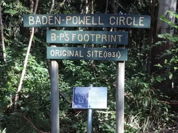 Concrete slab with a foot-shaped indentation beneath a Baden-Powell Circle signpost.