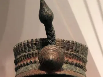 Bronze Head from Ife with fine vertical facial striations, closed eyes, and an elaborate headdress.