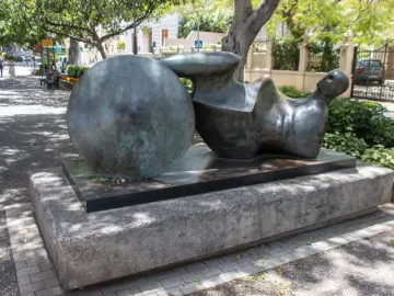 The Goslar Warrior bronze sculpture with an abstract reclining form and spherical element on a stone plinth.