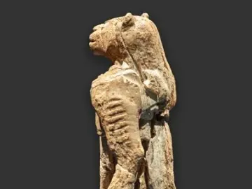 Lion-man statue shown from the left side, with a lion-like head and fragmented human body.