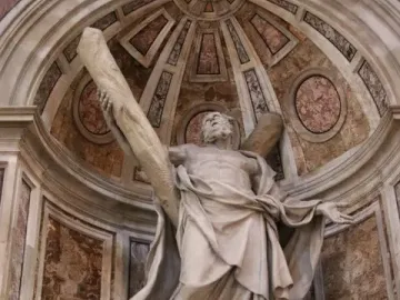 Saint Andrew sculpture in a vaulted niche, holding a large wooden beam and looking upward.