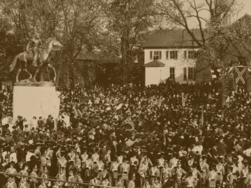 Stonewall Jackson equestrian statue on a pedestal with a large crowd gathered around it.