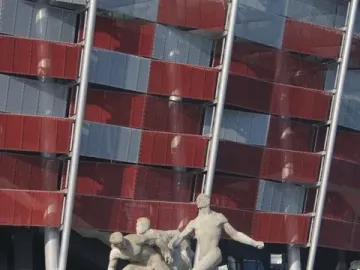 Sztafeta sculpture showing three male figures in dynamic running poses on a stone pedestal.