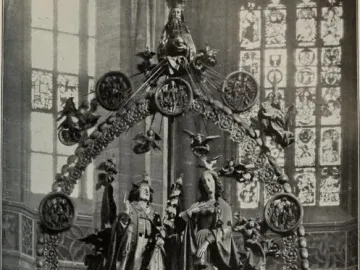 Angelic Salutation, an ornate sculptural ensemble with an angel and woman standing inside a circular wreath, surrounded by small figures and topped by a crowned figure.
