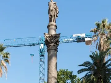 Galceran Marquet Monument with a stone column and standing figure, set in a fountain with bronze marine figures in Barcelona.