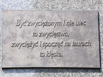 Bronze plaque with raised Polish text on the Józef Piłsudski Monument.