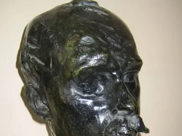 Bust of Octave Mirbeau with a prominent mustache on a tiered stone base