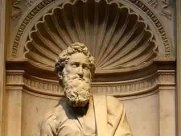Marble statue of Saint Paul standing in an ornate niche with flowing robes and a bearded face.