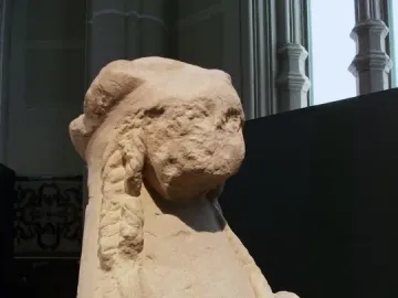 Detail of the Sphinx of Agost showing the eroded human-like head and winged upper body in limestone.